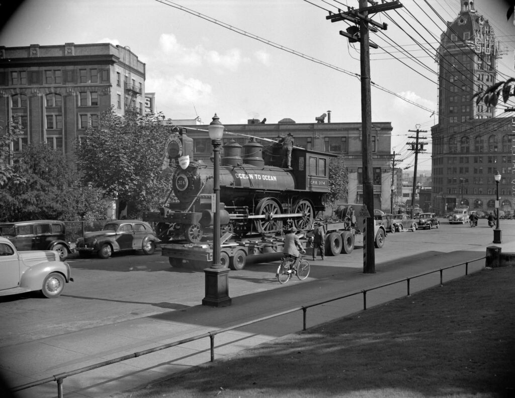 Engine 374 being transported by flatbed trailer along Pender Street in 1945.