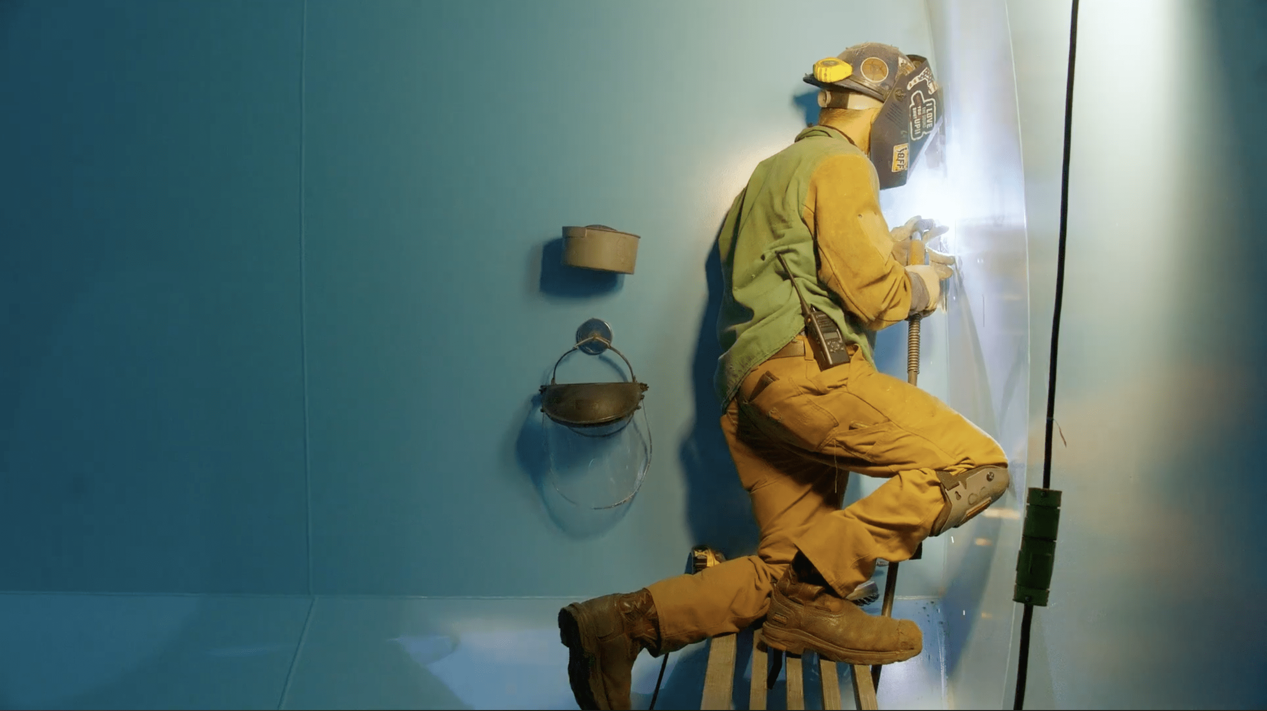 A manufacturing worker welding inside of a railcar