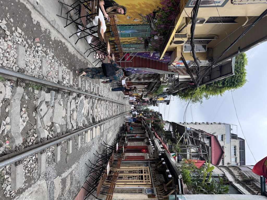 Café tables and chairs beside the railway track on Hanoi Train Street